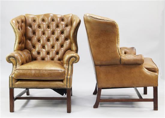 A pair of large leather wingback armchairs,